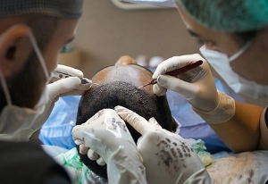 A man recieving a hair transplant from doctors.